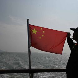 Bandera china, con el telón de fondo de las islas taiwanesas (en la parte trasera) desde una distancia de 2 kilómetros, durante un recorrido en barco para ver las islas. Foto de GREG BAKER / AFP | Foto:AFP