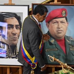 El presidente venezolano, Nicolás Maduro, pasa junto a la espada del libertador Simón Bolívar y las pinturas del fallecido presidente venezolano Hugo Chávez y del libertador Simón Bolívar mientras camina hacia el estrado para pronunciar su discurso sobre el estado de la nación ante el parlamento. | Foto:FEDERICO PARRA/AFP
