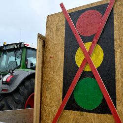 Se ve un tractor decorado con una bandera alemana junto a un cartel de semáforo tachado, en referencia al actual gobierno de Alemania de la llamada coalición "Ampel" de semáforos, durante una protesta de agricultores y camioneros, en Berlina. | Foto:JOHN MACDOUGALL / AFP