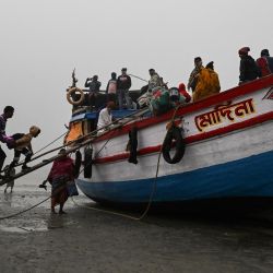Peregrinos hindúes caminan a bordo de un barco en la confluencia del río Ganges y la Bahía de Bengala después de asistir al Gangasagar mela en la isla de Sagar, a unos 150 kilómetros al sur de Calcuta. | Foto:DIBYANGSHU SARKAR / AFP