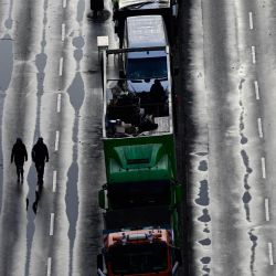 Tractores y camiones alineados en una calle durante una protesta de agricultores y camioneros en Berlín. La ira de los agricultores y camioneros se debe a la decisión del gobierno de recortar los subsidios y las exenciones fiscales a los vehículos agrícolas y diésel. | Foto:JOHN MACDOUGALL / AFP
