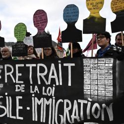 Los manifestantes marchan detrás de una pancarta que dice "retirada de la ley de inmigración" durante una manifestación contra la nueva ley de inmigración de Francia, en Burdeos. | Foto:PHILIPPE LOPEZ / AFP