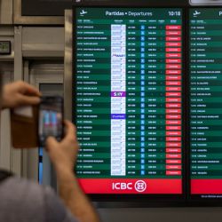 Un hombre toma una fotografía de una pantalla que muestra vuelos cancelados debido al paro nacional contra el gobierno de Javier Milei, en el aeropuerto Jorge Newbery de Buenos Aires. | Foto:TOMÁS CUESTA/AFP