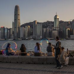 La gente visita un paseo junto al puerto Victoria en Hong Kong. | Foto:DALE DE LA REY / AFP