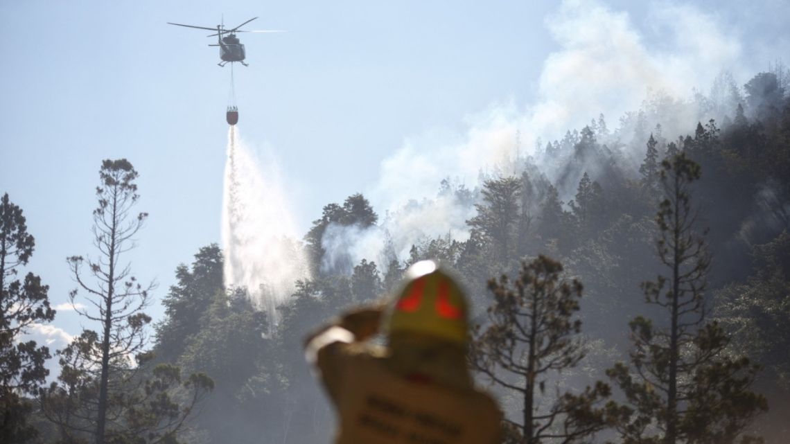 This handout picture released by Argentina's National Parks via Télam shows a helicopter dropping water to put out a forest fire at Los Alerces National Park in Chubut Province on January 26, 2024. 
