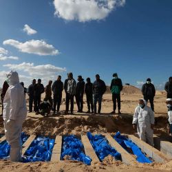 Los civiles observan cómo los trabajadores del Ministerio de Salud palestino con sede en Gaza entierran los cuerpos de palestinos no identificados. Foto de Mohammed ABED / AFP | Foto:AFP