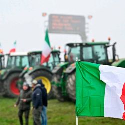 Una bandera nacional italiana frente a tractores estacionados a lo largo de la carretera durante una protesta de agricultores cerca de la entrada de la autopista en Melegnano. Foto de GABRIEL BOUYS / AFP | Foto:AFP