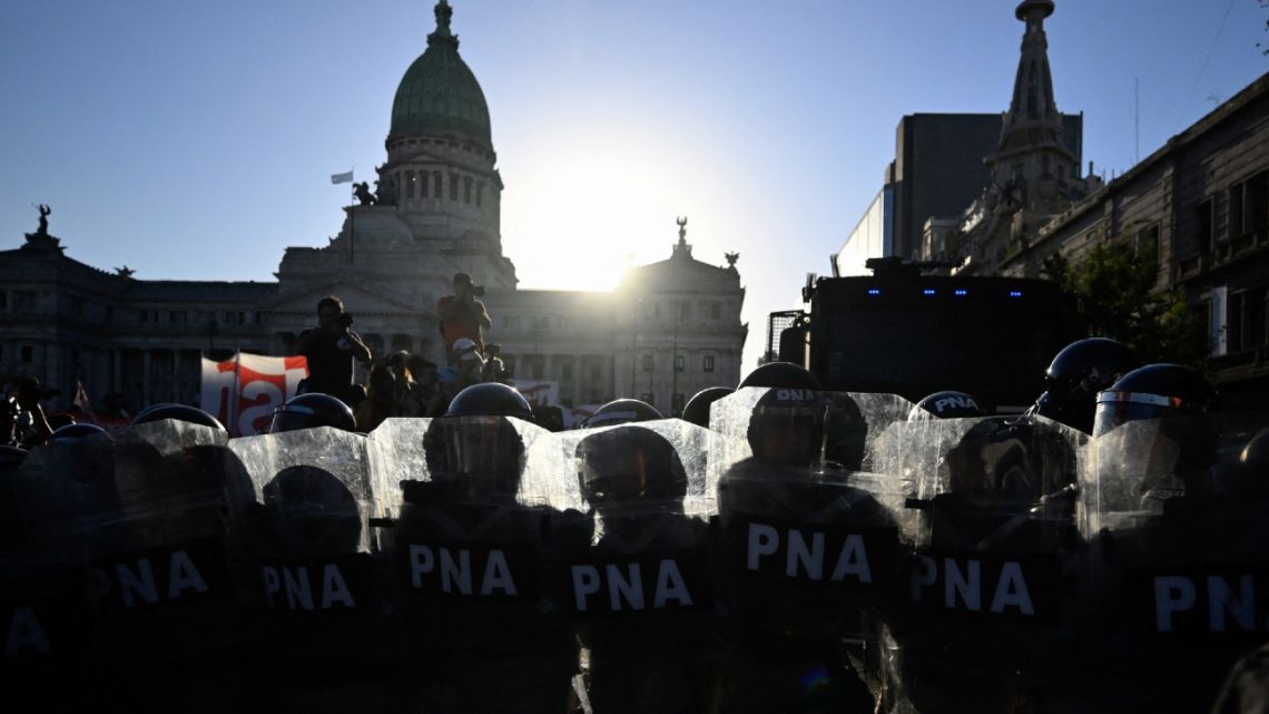 Members of the police stand guard while people hold a demonstration against President Javier Milei's 'Omnibus' bill outside the National Congress building, as lawmakers debate the bill inside,  in Buenos Aires on January 31, 2024.