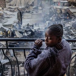 Una mujer mira desde un balcón las casas y tiendas gravemente dañadas, un día después de una explosión de gas en la zona de Embakasi de Nairobi. Foto de LUIS TATO/AFP | Foto:AFP