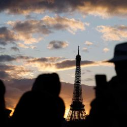 Turistas toman fotografías de la Torre Eiffel al atardecer, en París. Foto de Ludovic MARIN / AFP | Foto:AFP