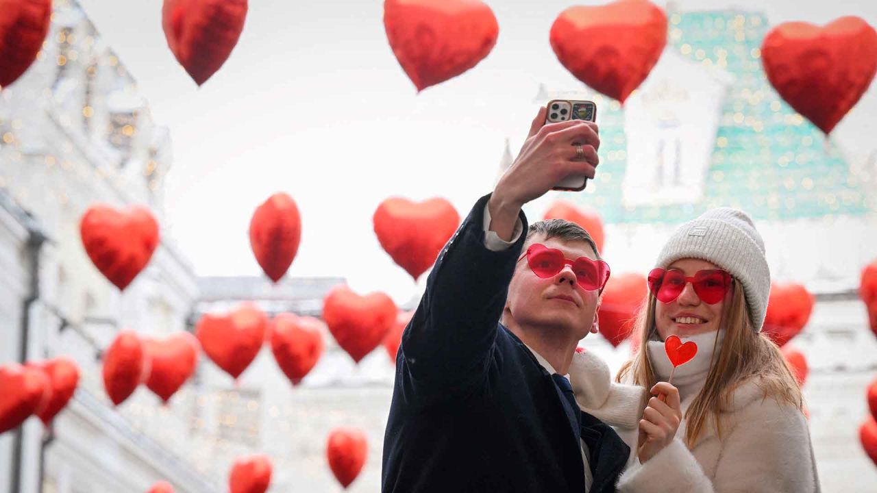 Una pareja se toma una foto bajo globos en forma de corazón exhibidos el día de San Valentín en el centro de Moscú. Foto de Natalia KOLESNIKOVA / AFP  | Foto:AFP