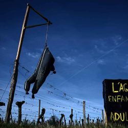 Un mono de trabajo de granjero disecado sobre una cruz y un cartel que dice "Agricultura: de niño sueñas, de adulto mueres" exhibido en un viñedo en Calignac, Francia. Foto de Philippe LÓPEZ / AFP | Foto:AFP