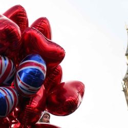 Una mujer sostiene globos con forma de corazón frente a la Torre Isabel, comúnmente conocida por el nombre de la campana del reloj "Big Ben", en el Palacio de Westminster. Foto de Adrián DENNIS / AFP | Foto:AFP
