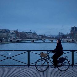 Una mujer anda en bicicleta por el puente Pont des Arts sobre el río Sena, en París. Foto de Kiran RIDLEY / AFP   | Foto:AFP