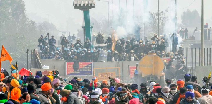 La policía y el personal de la Fuerza de Acción Rápida bloquean una carretera con gases lacrimógenos para impedir que los agricultores marchen hacia Nueva Delhi. Foto de Narinder NANU / AFP