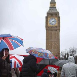 Los peatones se refugian de la lluvia bajo paraguas frente a la Torre Elizabeth, comúnmente conocida por el nombre de la campana del reloj, "Big Ben". Foto de HENRY NICHOLLS / AFP | Foto:AFP