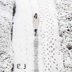 Una mujer camina por un sendero después de una nevada en Seúl. Foto de ANTHONY WALLACE / AFP  | Foto:AFP
