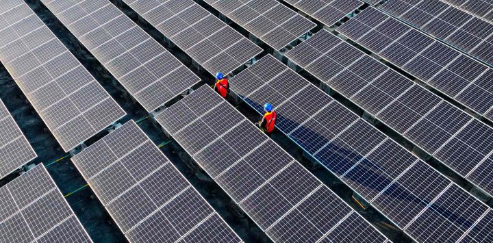 Trabajadores inspeccionando paneles solares en el tejado de una planta de energía en Fuzhou, en la provincia de Fujian. Foto de AFP
