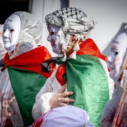Manifestantes enmascarados participan en la manifestación "Hands off Rafah" que pide un alto el fuego en Gaza, en Rotterdam. | Foto:Robin Utrecht / ANP / AFP