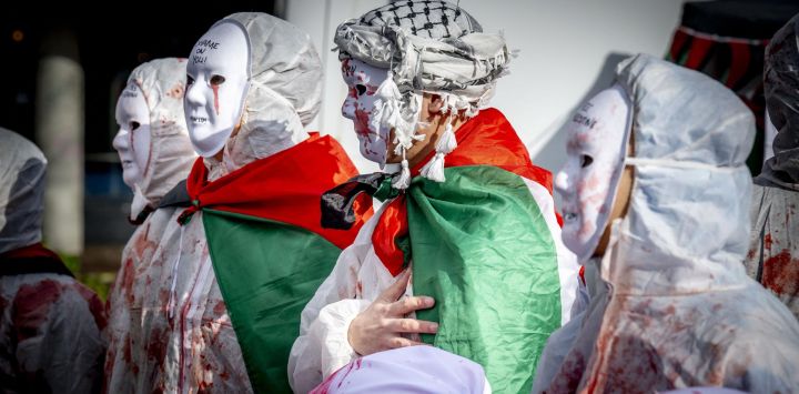 Manifestantes enmascarados participan en la manifestación "Hands off Rafah" que pide un alto el fuego en Gaza, en Rotterdam.