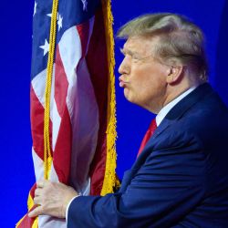 El ex presidente de Estados Unidos y aspirante a la presidencia de 2024, Donald Trump, besa la bandera de Estados Unidos cuando llega para hablar durante la reunión anual de la Conferencia de Acción Política Conservadora (CPAC), en National Harbor, Maryland. | Foto:MANDEL NGAN / AFP