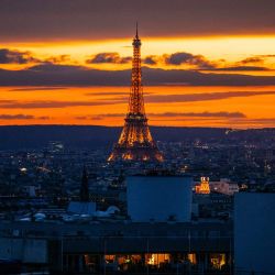 Esta fotografía tomada en París muestra la Torre Eiffel iluminada al atardecer. | Foto:DIMITAR DILKOFF / AFP