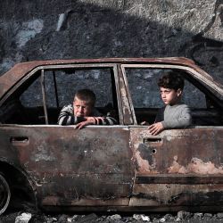 Niños sentados en un automóvil destruido en Rafah, en el sur de la Franja de Gaza, en medio de las batallas en curso entre Israel y el grupo militante palestino Hamás. | Foto:AFP