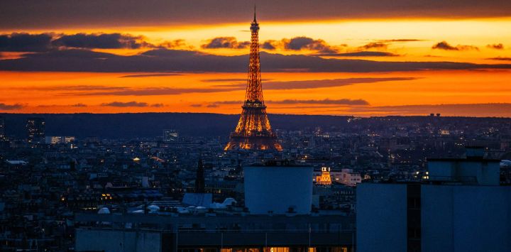 Esta fotografía tomada en París muestra la Torre Eiffel iluminada al atardecer.