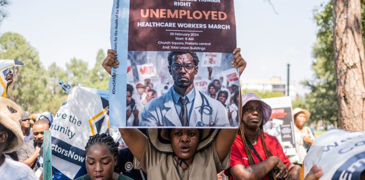 Los trabajadores de la salud sostienen pancartas durante una manifestación encabezada por el Sindicato de la Asociación Médica de Sudáfrica (SAMATU) para los trabajadores de la salud desempleados en el Union Building en Pretoria.
