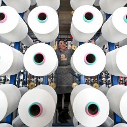 Un empleado revisa telas en una fábrica textil en Handan, en la provincia de Hebei, en el norte de China. | Foto:AFP