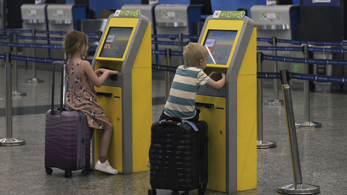 Children play with the self check-in machines at the Jorge Newbery airport during an aeronautical strike in Buenos Aires on February 28, 2024. Hundreds of flights were canceled or rescheduled this Wednesday in Argentina due to a 24-hour strike by aviation unions demanding better salaries, AFP confirmed.