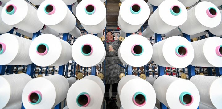 Un empleado revisa telas en una fábrica textil en Handan, en la provincia de Hebei, en el norte de China.