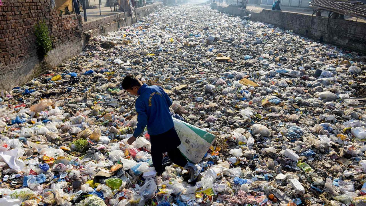 Un reciclador busca basura reciclable en un desagüe de aguas residuales utilizado como vertedero de basura, en un barrio pobre de Lahore. Foto de Syed MURTAZA / AFP | Foto:AFP