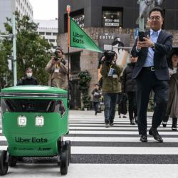 Caminan junto a un robot no tripulado mientras cruza la calle durante una demostración de un servicio de entrega de robots de Uber Eats Japan Tokio. Foto de Richard A./ AFP   | Foto:AFP