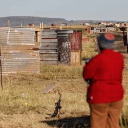 Un hombre mira las estructuras informales erigidas en un campo cerca del vecindario de Lourier Park en las afueras de Bloemfontein. Foto de Marco LONGARI / AFP  | Foto:AFP