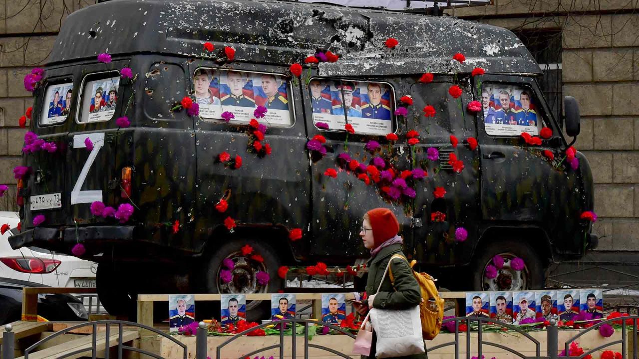 Una mujer pasa junto a un vehículo médico del ejército ruso con retratos de militares rusos, que fue dañado durante el conflicto entre Rusia y Ucrania. Foto de Olga MALTSEVA / AFP | Foto:AFP