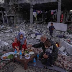 La familia palestina Al-Naji se prepara para romper su ayuno musulmán del Ramadán, sentada en medio de las ruinas de su casa familiar en Deir el-Balah. Foto de AFP | Foto:AFP