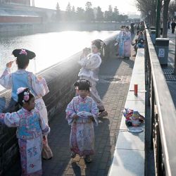 Personas vestidas con ropa al estilo de la dinastía Qing toman fotografías junto a un foso en las afueras de la Ciudad Prohibida en Beijing. Foto de WANG Zhao / AFP | Foto:AFP
