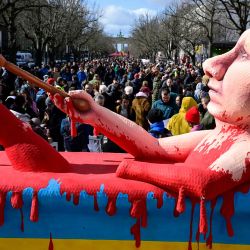 Una efigie del presidente ruso Vladimir Putin bañándose en un baño de sangre se ve en una manifestación frente a la embajada rusa en Berlín, donde los votantes hicieron fila para emitir su voto en las elecciones presidenciales de Rusia. | Foto:Tobias Negro / AFP