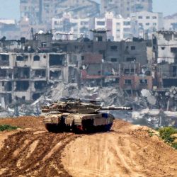 Esta fotografía tomada desde la frontera sur de Israel con la Franja de Gaza muestra un tanque de batalla del ejército israelí en una posición a lo largo de la frontera con el territorio palestino, en medio del conflicto en curso entre Israel y el grupo militante Hamas. | Foto:JACK GUEZ / AFP