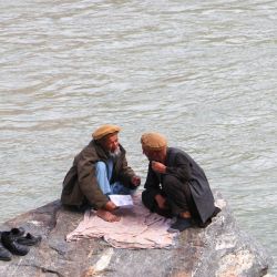 Hombres afganos sentados junto al río Kokcha en Fayzabad. | Foto:OMER ABRAR / AFP
