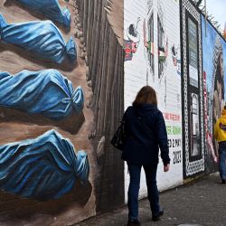 Los peatones pasan junto a un mural pintado en solidaridad con el pueblo de Palestina, en el Muro Internacional de Falls Road en Belfast, Irlanda del Norte. | Foto:PAUL ELLIS / AFP