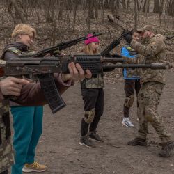 Mujeres civiles ucranianas practican con armas mientras asisten a un entrenamiento para mujeres centrado en el uso de armas y botiquín médico de combate, en Kiev, en medio de la invasión rusa de Ucrania. | Foto:Román Pilipey / AFP