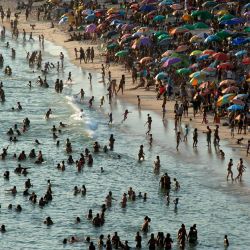 Vista aérea de personas disfrutando de la playa Recreio dos Bandeirantes en medio de una ola de calor en Río de Janeiro, Brasil. Una nueva ola de calor está azotando Brasil, con temperaturas récord que expulsaron a los residentes de Río de Janeiro y Sao Paulo para derramarse sobre playas y parques. | Foto:TERCIO TEIXEIRA / AFP