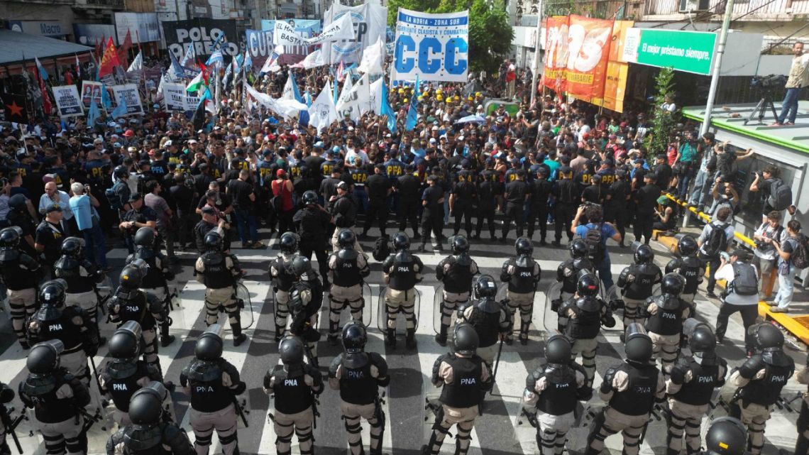 Aerial view showing security forces standing guard as members of social movements protest against cuts by the government of President Javier Milei in the most vulnerable sectors, on March 18, 2024, at the Pueyrredon bridge in Avellaneda, Buenos Aires Province, Argentina.