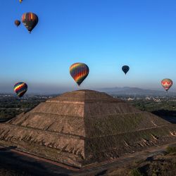 Globos aerostáticos sobrevuelan las pirámides de Teotihuacán en el municipio de San Juan Teotihuacán, Estado de México, durante la celebración del equinoccio de primavera. | Foto:CARL DE SOUZA / AFP
