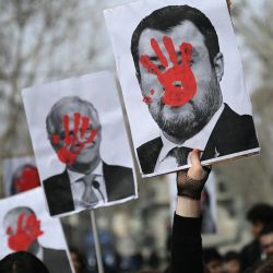 Los estudiantes sostienen retratos del viceprimer ministro italiano Matteo Salvini con una mano roja pintada en la cara, durante una protesta contra el gobierno italiano en Turín, noroeste de Italia. | Foto:MARCO BERTORELLO / AFP