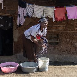 Una mujer lava ropa afuera de su casa en el barrio pobre de Mathare en Nairobi, Kenia. | Foto:SIMON MAINA / AFP
