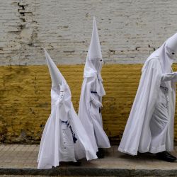 Penitentes de la cofradía de La Paz llegan para participar en la procesión del Domingo de Ramos en Sevilla, España. | Foto:CRISTINA QUICLER / AFP