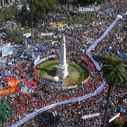 Vista aérea de cientos de personas sosteniendo una gran pancarta con retratos de personas desaparecidas durante la dictadura militar (1976-1983) al llegar a la Plaza de Mayo para conmemorar el 48 aniversario del golpe de estado en Buenos Aires. | Foto:LUIS ROBAYO/AFP